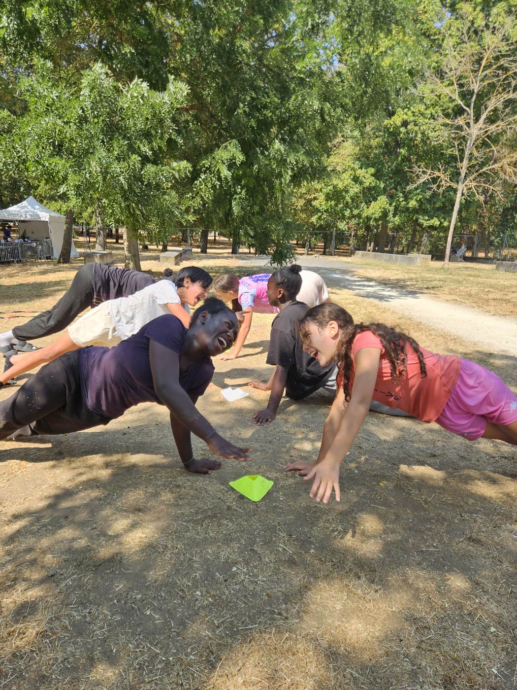Jeunes en position de gainage lors d'un challenge collectif en extérieur