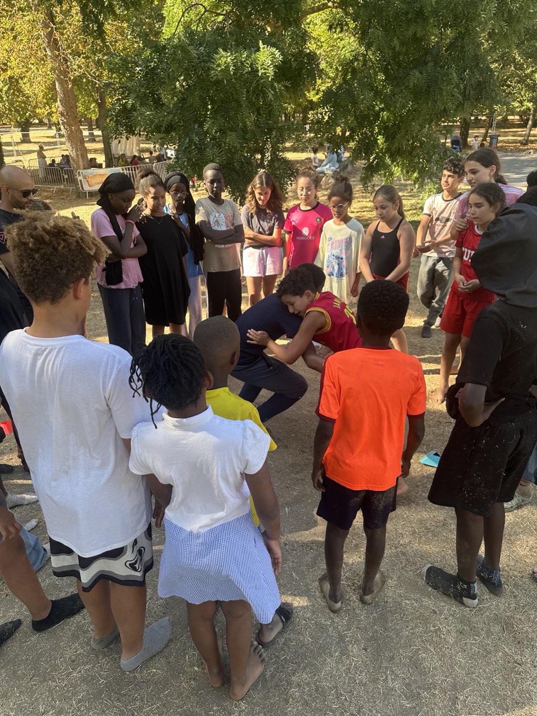 Groupe de jeunes autour d'un exercice de lutte encadré